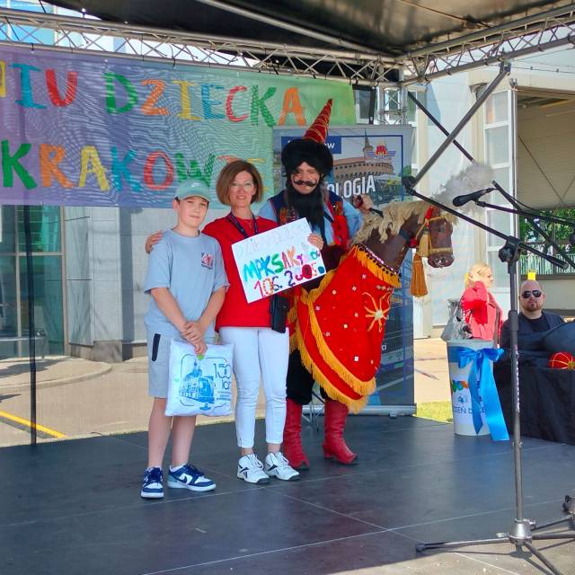 Dziecko prezentuje pracę plastyczną w ramach podziękowań dla MPK w Krakowie
